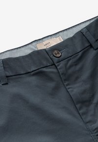 Pantaloni slim-fit di un blu navy scuro realizzati in morbido cotone, con chiusura a un pulsante e una sottile fodera testurizzata in vita.
