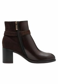 Bottine en cuir marron avec un bout rond, une fermeture éclair sur le côté et un talon chunky. Des accents en daim et une texture lisse sont présents.