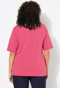 Chemise à manches courtes rayée rouge et blanche avec une coupe décontractée, dotée d'un col rond et d'un tissu lisse et léger.