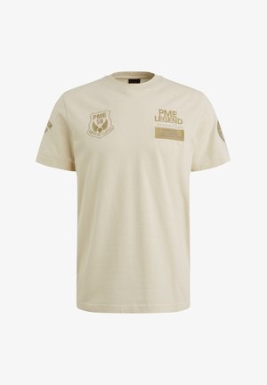 Krem majica od pamuka s izvezenim aplikacijama s natpisima i logotipima u nijansama zlatne, okrugli izrez i kratki rukavi.