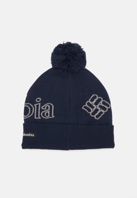 Jūras spēku adīts cepure ar pom-pom augšā. Iekļauj pelēku tekstu un logotipu priekšā, kā arī ribotu joslu apakšā.