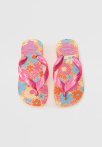 Sandales ar flip-flopi ar brūnu pamatni, kas rotātas ar krāsainu ziedu apdruku rozā, zilā un oranžā krāsā, ar spīdīgi rozām gumijas siksnām ar teksturētu apdari.