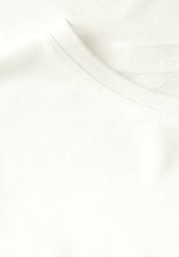Hvid bomuld t-shirt med rund hals og glat tekstur. Enkel design uden mønstre eller yderligere accenter.