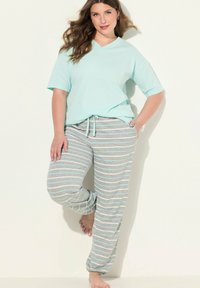 Světle tyrkysové tričko s výstřihem do V v kombinaci se šedými a světle modrými pruhovanými pyžamovými kalhotami. Kalhoty mají pružný pas na šňůrku a volný střih.