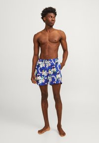 Blauwe bloemen zwemshorts met een tropisch patroon van groene en roze accenten, verstelbare koordtaille en zijzakken.