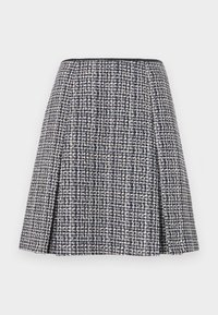 Laivastonsininen tweed-hame, jossa on teksturoitu kuvio, levenevä siluetti ja laskokset. Vyötärö on musta, mikä korostaa hameen muotoilua.