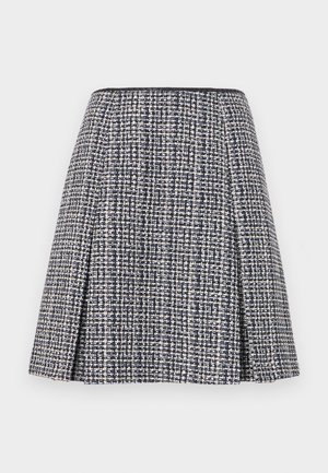 Marineblå tweed skjørt med et teksturert mønster, utvidet silhuett og folder. Livdelen er svart, noe som fremhever skjørtets design.