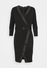 Robe portefeuille noire avec un décolleté en V, des manches longues et des accents en satin. Caractérisée par une silhouette ajustée et un ourlet à hauteur du genou. Fermeture éclair au dos.