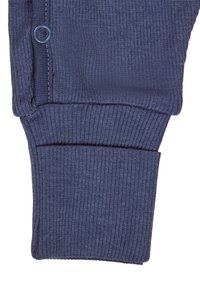 Dunkelblaues geripptes Strickbündchen mit einem Knopf und einer weichen Textur, das für eine enge Passform mit sauberem Stich entlang der Kante entworfen wurde.