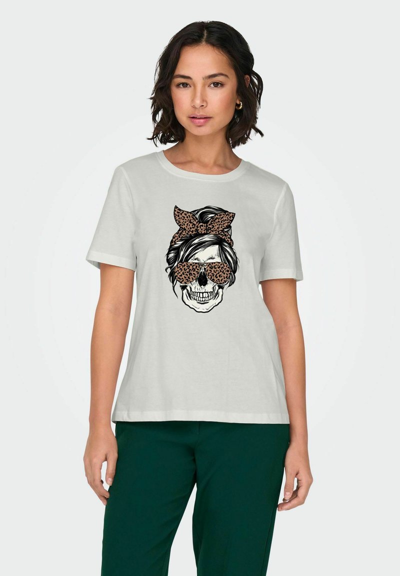 T-shirt gris clair avec un graphique d'un crâne portant des lunettes de soleil et un nœud en imprimé léopard. Manches courtes et coupe décontractée.