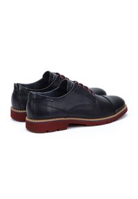 Chaussures en cuir noir avec une finition lisse, design perforé sur les côtés, semelles rouges contrastantes et lacets rouges. Accents cousus mis en avant.