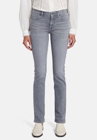 Jean en denim gris clair avec une coupe droite classique. Il présente des poches avant, une fermeture éclair et des coutures discrètes le long des bords.