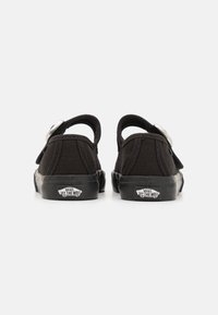 Melni kanvas slip-on apavi ar gumijas zoli, aizmugures skats. Iespējas: sudraba sprādze, izšūti akcenti un Vans logo uz papēža.