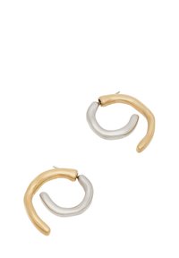 Dos pendientes de aro en oro y plata, con una forma irregular y retorcida, que presentan una superficie lisa y brillante, además de un grosor ligero.