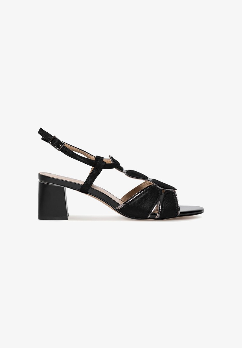 Sandalias negras de tacón con tacón cuadrado, que presentan una combinación de materiales lisos y texturizados, diseños troquelados y una correa para el tobillo ajustable.