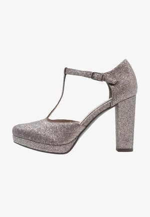 Escarpins plateformes argentés pailletés avec un design à T, un bout arrondi et des talons carrés. La surface présente une texture étincelante.