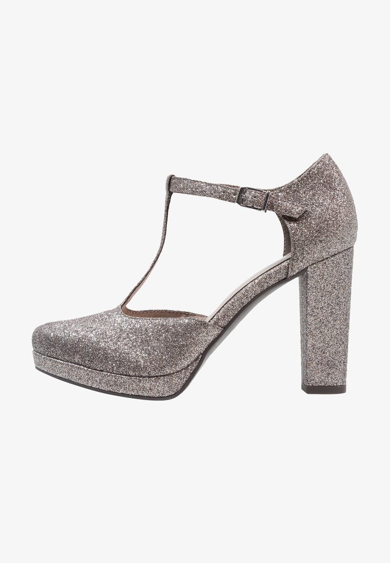 Escarpins plateformes argentés pailletés avec un design à T, un bout arrondi et des talons carrés. La surface présente une texture étincelante.