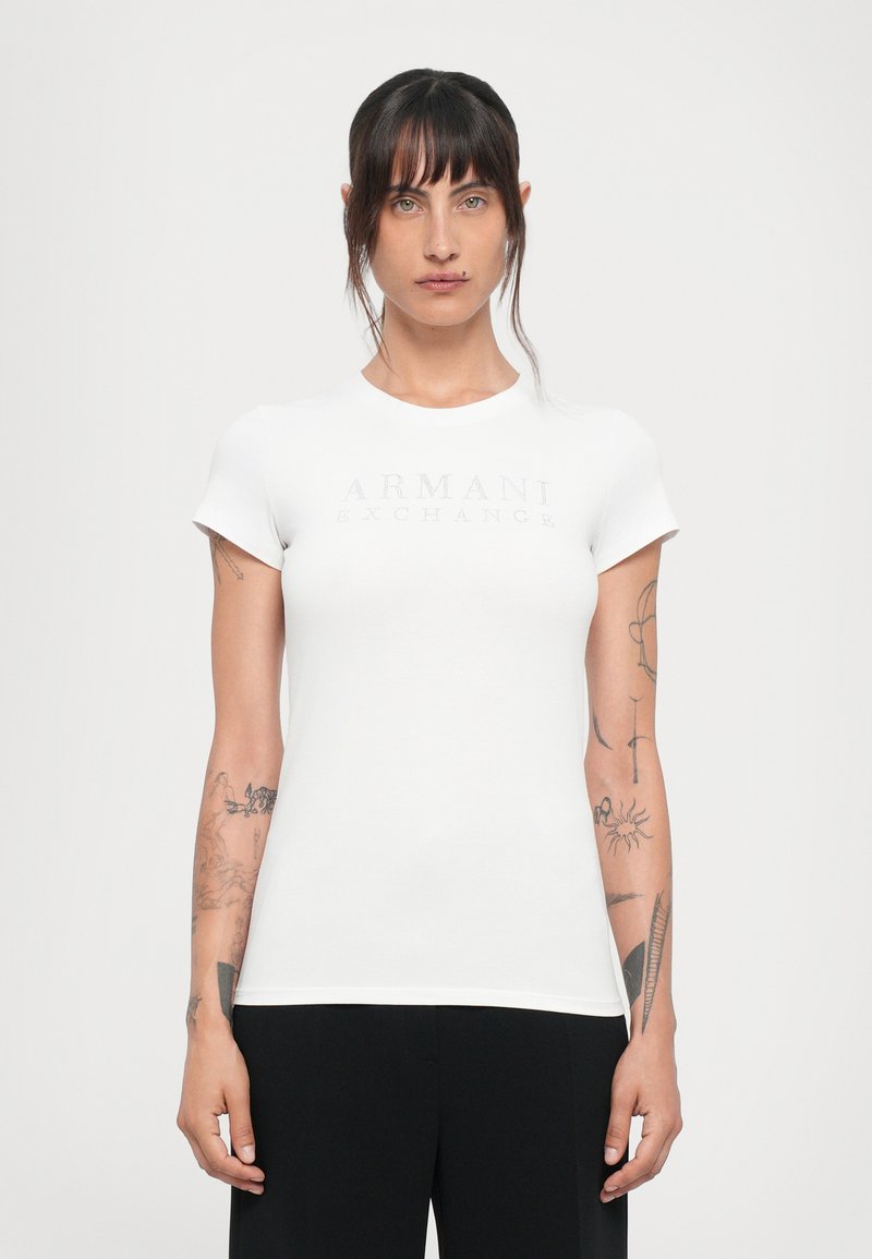 Witte aansluitende t-shirt met korte mouwen en een ronde halslijn, met een reflecterend "ARMANI EXCHANGE" logo op de borst.