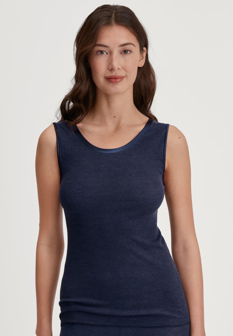 Navy blauwe top met een ronde halslijn en smalle schouderbanden, gemaakt van zachte, rekbare stof. Soepele textuur, minimale naden.