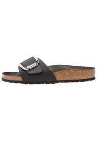 Svart slide-sandal med en texturerad korkfotbädd, ett brett rem som har en silverfärgad rektangulär spänne och en hållbar gummisula.