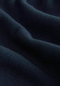 Tâsă de tricot navy cu o suprafață texturată, având modele ridicate, care prezintă pliuri și ondulații delicate. Aspectul materialului este moale și uniform.