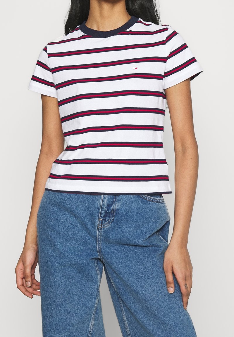Camiseta de algodón con rayas horizontales rojas y azul marino sobre un fondo blanco, con un cuello redondo azul marino y un pequeño logo en el pecho.