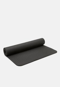 Musta joogamatto, jossa on teksturoitu pinta ja kierretty reuna. Yläpuolella on hienovarainen lehden kuvio ja alaosassa uritettu rakenne.