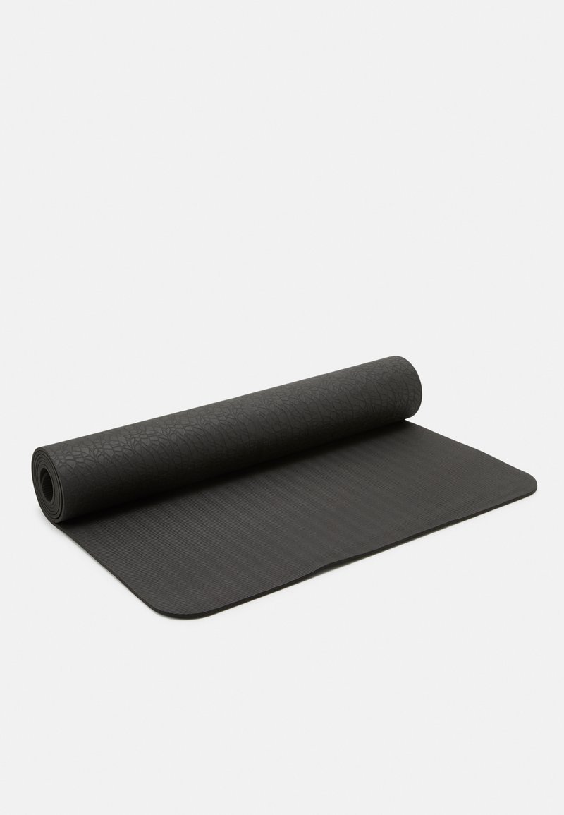 Musta joogamatto, jossa on teksturoitu pinta ja kierretty reuna. Yläpuolella on hienovarainen lehden kuvio ja alaosassa uritettu rakenne.