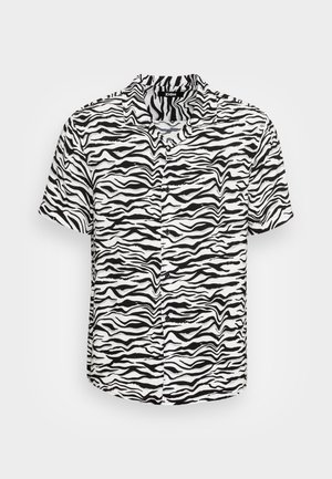 Chemise à manches courtes avec un motif zèbre noir et blanc, dotée d'un col et d'une patte de boutonnage, confectionnée en tissu léger.