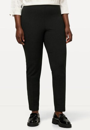 Zwart op maat gemaakte broek met een slim fit, textuurstof en een middelhoge tailleband, gecombineerd met glanzende zwarte instappers.