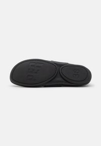 Semelle de chaussure noire avec grip texturé, comportant le mot "PER" à l'avant et le numéro "38" près du talon.