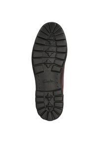 Tălpic din cauciuc negru cu un profil adânc, texturat și cu branding "Clarks". Design robust, potrivit pentru aderență și durabilitate.