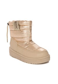 Stivaletti alla caviglia metallici dorati con texture imbottita, punta arrotondata e suola in gomma beige. Presentano una parte superiore con cordoncino e una patch con logo.