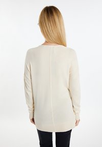 Beige Strickpullover mit lässiger Passform, langen Ärmeln und geripptem Saum und Bündchen. Verfügt über eine Mittelnaht auf der Rückseite.