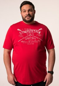 T-shirt rossa a maniche corte in cotone, con una stampa grafica bianca di remi e la parola "Competizione" sul davanti.