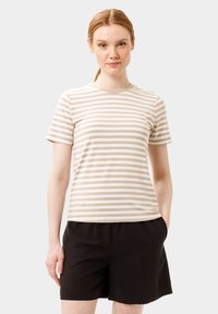 Camiseta de manga corta a rayas beige y blanca con escote redondo, combinada con pantalones cortos negros. La tela parece suave y casual.