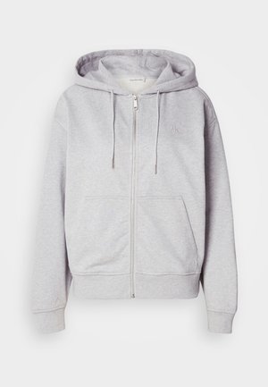 Pelēks zip-up kapucis, kas izgatavots no mīksta auduma, ar regulējamu kapuci, divām priekšējām kabatām un diskrētu logo uz krūtīm.