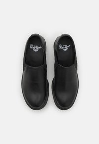 Scarpe nere in pelle a slip-on con pannelli elastici laterali, punta rotonda e suola in gomma testurizzata. Presentano il logo "Dr. Martens" sulla soletta.