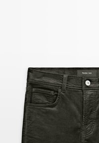 Pantaloni in corduroy grigi con vita strutturata, dotati di due tasche frontali, chiusura con bottone e etichetta con la scritta "Massimo Dutti."