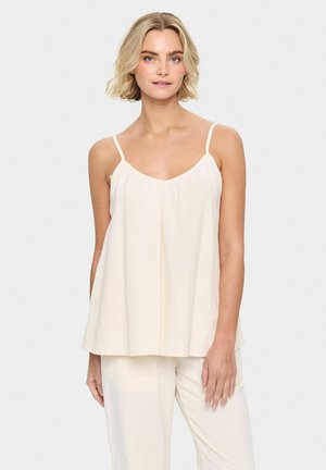 Top in crema leggero senza maniche, con spalline sottili, scollatura a V e vestibilità morbida. Il tessuto appare morbido con una texture sottile.