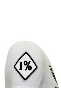Wit katoenen t-shirt met een zwart diamantvormig stuk stof met "1%" in vette letters op de mouw, met een gladde textuur.