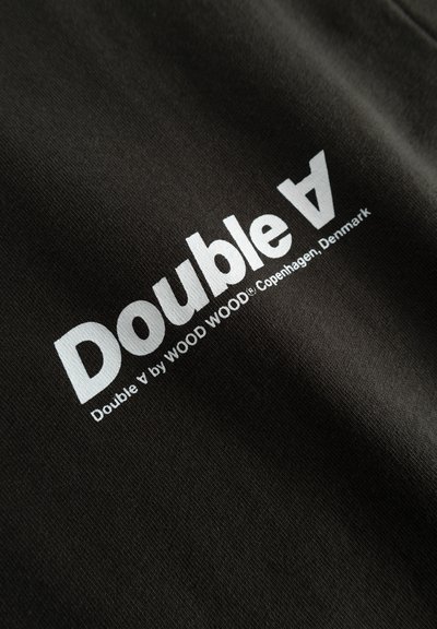 Tessuto nero con logo "Double A" bianco e il testo "Double A by WOOD WOOD Copenhagen, Denmark". Tessuto liscio e stile del font moderno.
