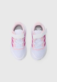 Scarpe da ginnastica bianche e rosa con materiale in mesh, dettagli rosa, cinturino a strappo e suola in gomma testurizzata. Presentano lacci e dettaglio con logo.