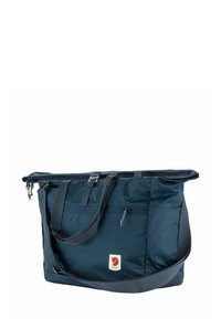 Donkerblauwe stoffen tas met dubbele handvatten en een verstelbare schouderriem, met een voorste ritsvak en een logopatch aan de zijkant. Rechthoekige vorm.