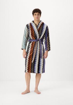 Accappatoio multicolore a zigzag realizzato in tessuto morbido. Caratterizzato da un girovita con cintura, maniche lunghe e due tasche laterali.