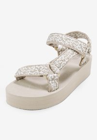 Sandalias de plataforma beige con correas de textil trenzado que presentan un patrón sutil, suela de goma flexible y cierres ajustables de gancho y bucle.