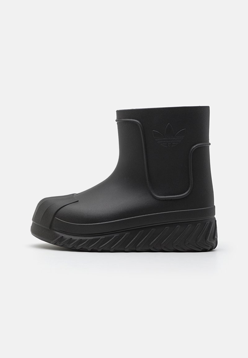 Botín negro impermeable hasta el tobillo con suela de goma texturizada, parte superior lisa, logotipo elevado y diseño de puntera redonda. Presenta un estilo sin esfuerzo con una construcción robusta.