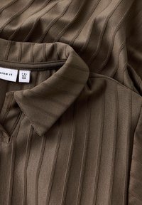 Rjava rebrasta polo majica s ovratnikom, z vertikalno teksturo in oznako velikosti 7-8, 122-128. Mehka tkanina.