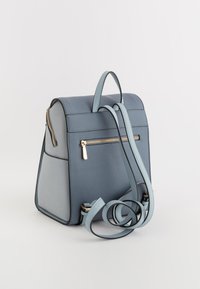 Rucsac din piele albastră, cu o formă structurată, având un buzunar frontal cu zip, bretele reglabile și mânere plate. Suprafață texturată cu accesorii din aur.