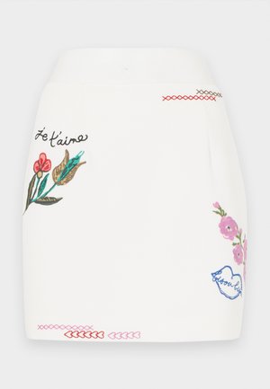 Weißer Rock mit buntem floralen Stickerei in Pink, Rot und Grün. Beinhaltet dekorative Nähdetails am Saum sowie den Satz "Je t'aime."